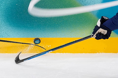 Finland's Miro Heiskanen (41), right, tries to control the puck during a men's ice hockey quarterfinal game between Finland and Switzerland at the 2026 Winter Olympics, in Milan, Italy.