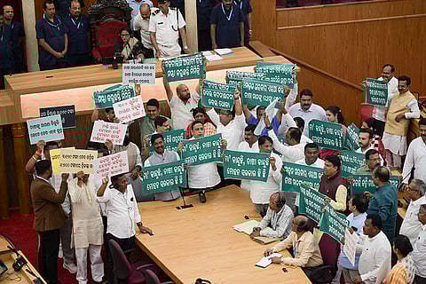 Opposition MLAs stage a protest during the Budget session of the Odisha Assembly, in Bhubaneswar.