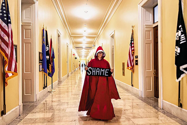 Speaking Up: A woman dressed in the red cloak and white bonnet of The Handmaid’s Tale lobbies Congress to release the Epstein files - | Photo: Imago/Zuma Press Wire