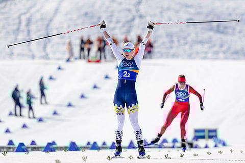 Maja Dahlqvist, of Sweden, crosses the finish line to win the gold medal, ahead of Nadine Faehndrich, of Switzerland, in the cross-country skiing women's team sprint free at the 2026 Winter Olympics, in Tesero, Italy.