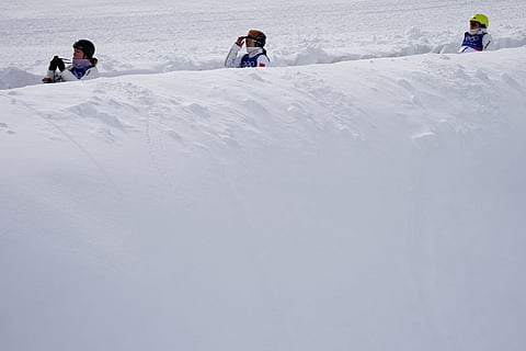 Athletes ride the magic carpet before the women's freestyle skiing aerials finals at the 2026 Winter Olympics, in Livigno, Italy.