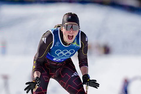 Coletta Rydzek, of Germany, reacts after crossing the finish line to win the bronze medal in the cross-country skiing women's team sprint free at the 2026 Winter Olympics, in Tesero, Italy.