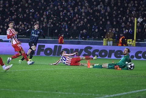 Brugge's Christos Tzolis, second from left, scores his side's third goal past Atletico Madrid's goalkeeper Jan Oblak during the Champions League play-off first leg soccer match between Club Brugge and Atletico Madrid, in Bruges, Belgium.
