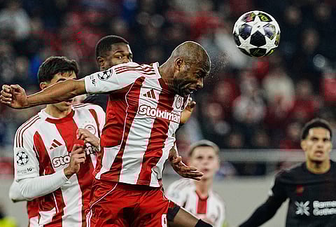 Olympiacos' Ayoub El Kaabi heads the ball during a UEFA Champions League playoff match against Bayer 04 Leverkusen at the port of Piraeus, near Athens.