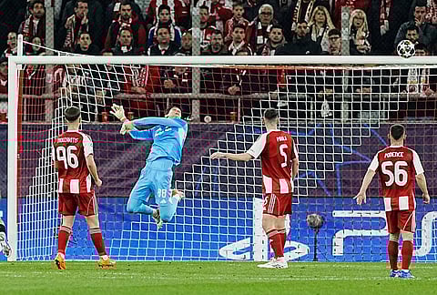 Olympiacos' goalkeeper Konstantinos Tzolakis saves the ball against the woodwork during a Champions League playoff soccer match between Olympiacos and Bayer 04 Leverkusen in Piraeus port, near Athens.
