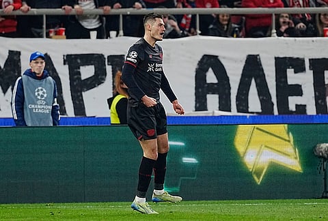 Leverkusen's Patrik Schick, right, celebrates after scoring the first goal against Olympiacos during a Champions League playoff soccer match between Olympiacos and Bayer 04 Leverkusen in Piraeus port, near Athens.