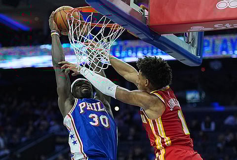 Philadelphia 76ers' Adem Bona (30) dunks against Atlanta Hawks' Jalen Johnson during the second half of an NBA basketball game in Philadelphia.