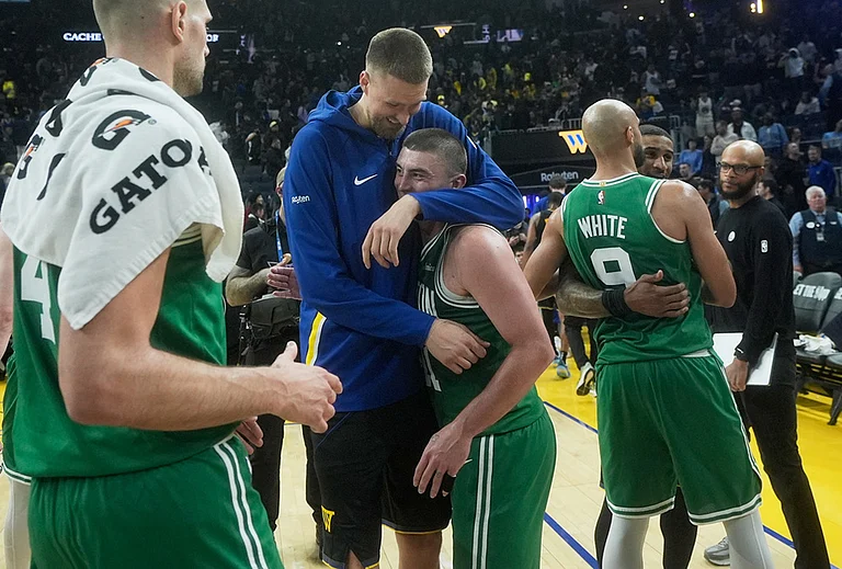 Golden State Warriors center Kristaps Porziņģis, top middle, hugs Boston Celtics guard Payton Pritchard as Celtics guard Derrick White (9) hugs Warriors guard Gary Payton II after an NBA basketball game in San Francisco. - | Photo: AP/Jeff Chiu