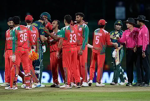 Oman's players congratulate Australia's captain Mitchell Marsh, centre, after winning the T20 World Cup cricket match between Australia and Oman in Pallekele, Sri Lanka.