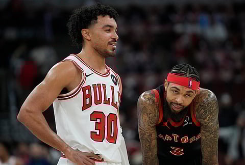 Chicago Bulls guard Tre Jones (30) and Toronto Raptors forward Brandon Ingram (3) stand together in the last few seconds of the game during the second half of an NBA basketball game in Chicago.