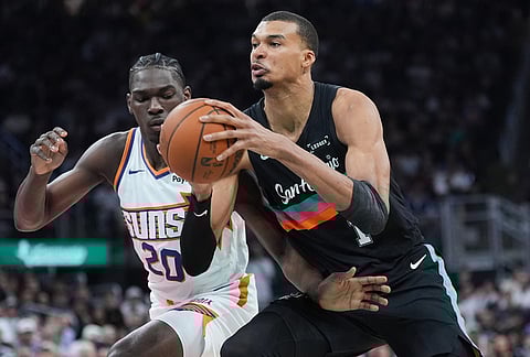 San Antonio Spurs forward Victor Wembanyama (1) drives against Phoenix Suns forward Rasheer Fleming (20) during the second half of an NBA basketball game in Austin, Texas.