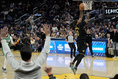 Golden State Warriors guard Gary Payton II (0) dunks against the Boston Celtics during the second half of an NBA basketball game in San Francisco.