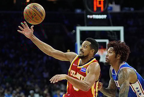 Atlanta Hawks' CJ McCollum, left, reaches for a loose ball next to Philadelphia 76ers' Kelly Oubre Jr. during the first half of an NBA basketball game in Philadelphia.