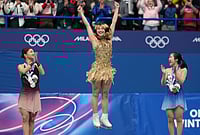 | Photo: AP/Stephanie Scarbrough : From left to right, silver medalist Kaori Sakamoto of Japan, gold medalist Alysa Liu of the United States, and bronze medalist Ami Nakai of Japan, jump on the podium to receive their medals after competing in the women's free skate program in figure skating at the 2026 Winter Olympics, in Milan, Italy.