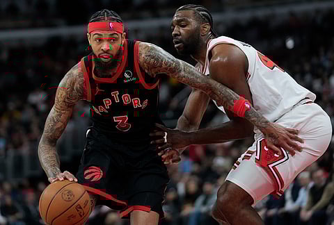 Toronto Raptors forward Brandon Ingram, left, handles the ball as Chicago Bulls forward Patrick Williams, right, defends during the second half of an NBA basketball game in Chicago. 