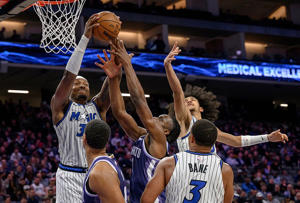 | Photo: AP/Randall Benton : Orlando Magic center Wendell Carter Jr., left, guard Anthony Black, and guard Desmond Bane battle for a rebound with Sacramento Kings forward Precious Achiuwa during the second half of an NBA basketball game in Sacramento, 
California.