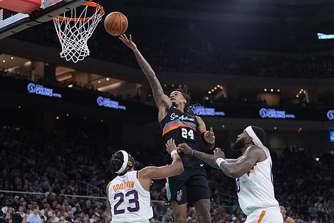 San Antonio Spurs guard Devin Vassell (24) drives to the basket over Phoenix Suns guard Jordan Goodwin (23) during the second half of an NBA basketball game in Austin, Texas.