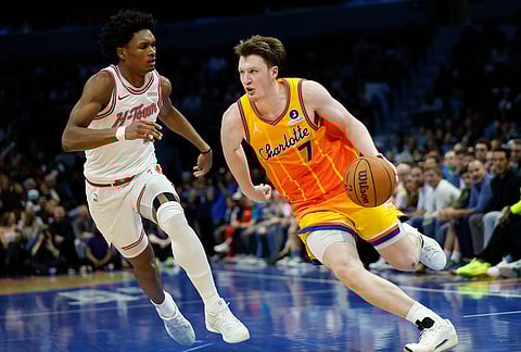 Charlotte Hornets guard Kon Knueppel (7) drives to the basket against Houston Rockets guard Amen Thompson, left, during the second half of an NBA basketball game in Charlotte, North Carolina.