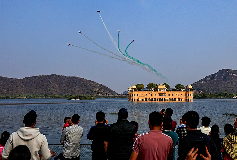 Indian Air Force's (IAF) Surya Kiran Aerobatic Team (SKAT) performs manoeuvres over the Jal Mahal during full dress rehearsal ahead of the Sarang and Surya Kiran Air Show, in Jaipur, Rajasthan. - | Photo: PTI
