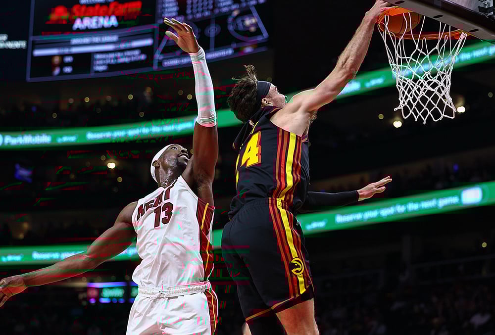 | Photo: AP/Colin Hubbard : Atlanta Hawks forward Corey Kispert, right, dunks against Miami Heat center Bam Adebayo, left, during the first half of an NBA basketball game, in Atlanta. 