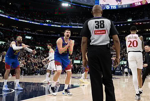 Denver Nuggets center Nikola Jokic, center, pleads for a foul to referee Michael Smith during the second half of an NBA basketball game against the Los Angeles Clippers in Inglewood, California.