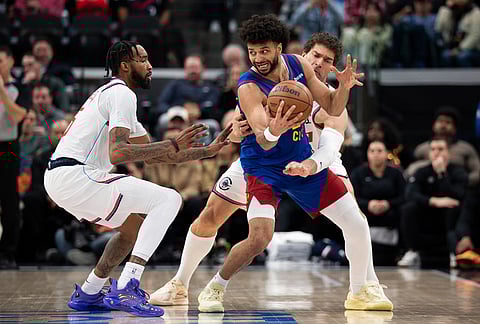 Los Angeles Clippers forward Derrick Jones Jr., left, and center Brook Lopez, back right, defend against Denver Nuggets guard Jamal Murray, front right, during the first half of an NBA basketball game in Inglewood, California.
