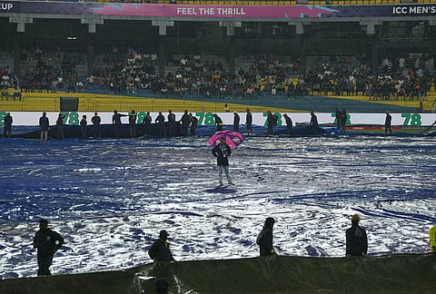 Groundsmen cover the field as it begins to rain before the start of the T20 World Cup cricket match between New Zealand and Pakistan in Colombo, Sri Lanka.