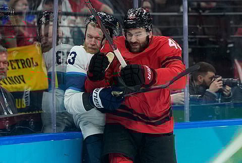Canada's Tom Wilson, right, challenges with Finland's Nikolas Matinpalo (33) during a men's ice hockey semifinal game between Canada and Finland at the 2026 Winter Olympics, in Milan, Italy.