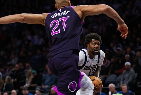 Dallas Mavericks' Klay Thompson (31) looks past Minnesota Timberwolves' Rudy Gobert (27) during the second half of an NBA basketball game in Minneapolis.