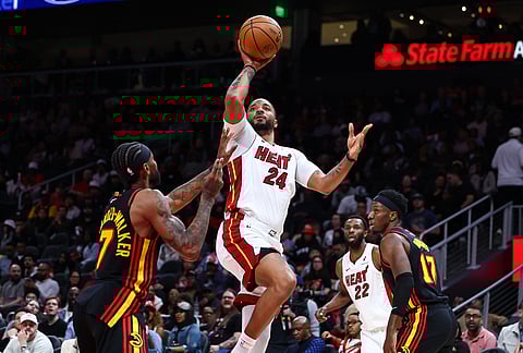 Miami Heat guard Norman Powell (24) goes up to shoot against Atlanta Hawks guard Nickeil Alexander-Walker, left, during the second half of an NBA basketball game, in Atlanta.