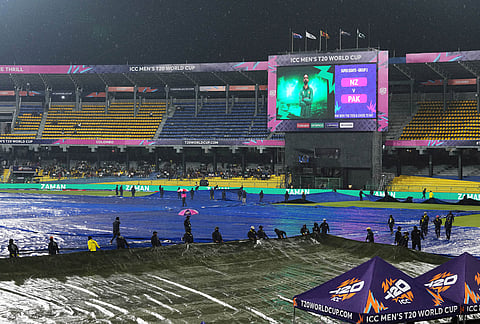 Groundsmen cover the field as it begins to rain before the start of the T20 World Cup cricket match between New Zealand and Pakistan in Colombo, Sri Lanka.
