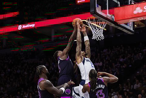 Minnesota Timberwolves' Anthony Edwards (5) reaches to block Dallas Mavericks' P. J. Washington Jr., top right, during the second half of an NBA basketball game in Minneapolis.