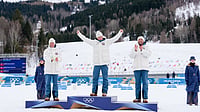 | Photo: AP/Evgeniy Maloletka : Silver medalist Martin Loewstroem Nyenget, gold medalist Johannes Hoesflot Klaebo and bronze medalist Emil Iversen, all three of Norway, stand on the podium of the cross country skiing men's 50km mass start Classic at the 2026 Winter Olympics, in Tesero, Italy, Saturday, Feb. 21, 2026.