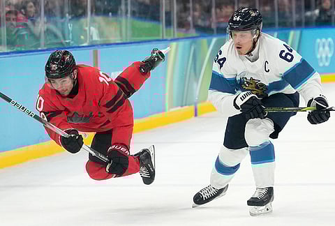 Canada's Nick Suzuki (10) challenges with Finland's Mikael Granlund (64) during a men's ice hockey semifinal game between Canada and Finland at the 2026 Winter Olympics, in Milan, Italy.