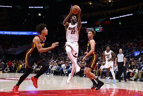 Miami Heat forward Andrew Wiggins (22) goesup to shoot against Atlanta Hawks forward Jalen Johnson, left, and guard Dyson Daniels, right, during the second half of an NBA basketball game, in Atlanta.
