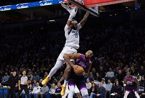 Dallas Mavericks' Daniel Gafford (21) goes against Rudy Gobert (27) at the basket during the first half of an NBA basketball game in Minneapolis.