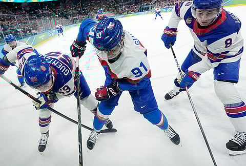 Slovakia's Matus Sukel (91) challenges with United States' Jake Guentzel (59) and United States' Zach Werenski (8) during a men's ice hockey semifinal game between the United States and Slovakia at the 2026 Winter Olympics, in Milan, Italy.