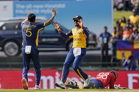 Sri Lanka's captain Dasun Shanaka, center, and Dushmantha Chameera, left, celebrate the runout of England's Tom Banton, right, during the T20 World Cup cricket match between Sri Lanka and England in Pallekele, Sri Lanka.