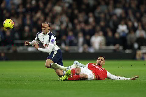 Tottenham's Xavi Simons, left, and Arsenal's William Saliba challenge for the ball during the English Premier League soccer match between Tottenham Hotspur and Arsenal in London.