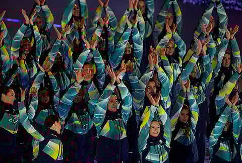 Olympic volunteers perform during the closing ceremony of the 2026 Winter Olympics, in Verona, Italy.