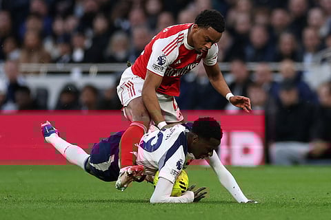Tottenham's Pape Matar Sarr and Arsenal's Jurrien Timber challenge for the ball during the English Premier League soccer match between Tottenham Hotspur and Arsenal in London.