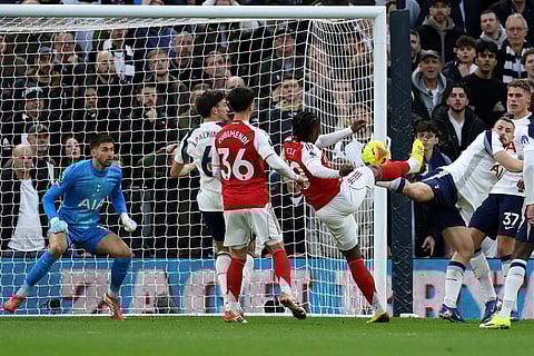 Arsenal's Eberechi Eze, center, shoots to score his side's first goal during the English Premier League soccer match between Tottenham Hotspur and Arsenal in London.