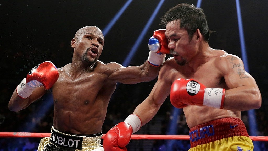 Floyd Mayweather Jr., left, hits Manny Pacquiao, from the Philippines, during their welterweight title fight on May 2, 2015, in Las Vegas. - File/AP