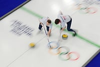 Winter Olympics 2026: Best Photos From Milan-Cortina Games | Photo: AP/David J. Phillip : United States' Aidan Oldenburg and Luc Violette sweep ahead of a stone during a men's curling round robin match against Canada at the 2026 Winter Olympics, in Cortina d'Ampezzo, Italy, Friday, Feb. 13, 2026.