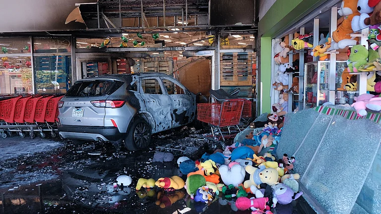 A charred vehicle sits at a damaged supermarket in Guadalajara, Jalisco state, Mexico, Sunday, Feb. 22, 2026, after the death of the leader of the Jalisco New Generation Cartel, Nemesio Rubén Oseguera Cervantes, known as "El Mencho." - (AP Photo/Alejandra Leyva)