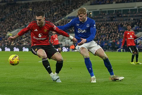 Manchester United's Diogo Dalot, left, and Everton's Jarrad Branthwaite fight for the ball during the Premier League soccer match between Manchester United and Everton in Liverpool, England.