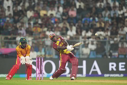 West Indies' Rovman Powell hits a six during the T20 World Cup cricket match between Zimbabwe and West Indies in Mumbai.