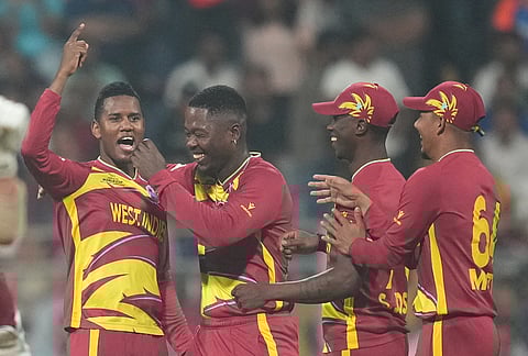 West Indies' Akeal Hosein, left, celebrates with teammates the wicket of Zimbabwe's Brian Bennett during the T20 World Cup cricket match between Zimbabwe and West Indies in Mumbai.