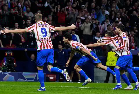 Atletico Madrid's Johnny Cardoso, center, celebrates after scoring his side's second goal during the Champions League play-off second leg soccer match between Atletico Madrid and Club Brugge, in Madrid, Spain.