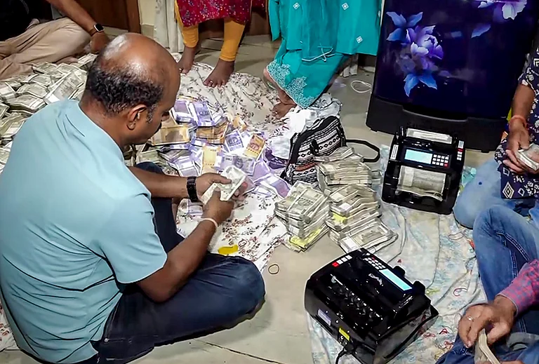 Odisha Vigilance officials count seized cash during a raid at the residence of arrested Deputy Director of Mines Debabrata Mohanty in connection with a bribery case, in Bhubaneswar. Over Rs 4 crore in cash was recovered during the raids, officials said. - | Photo: PTI